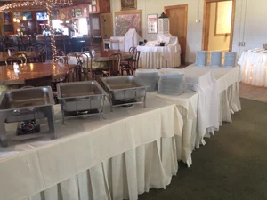 Buffet chafing dishes with bar area visible behind