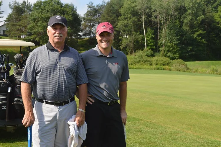 Two golfers posing on the fairway at Genegantslet Golf Club on a sunny day