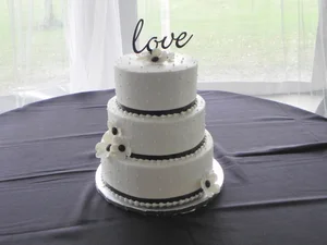 Three-tier white cake with love wire topper