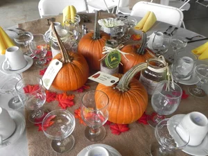 Pumpkin centerpiece with yellow napkins at fall wedding