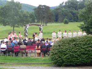 Wide outdoor ceremony shot with mountains behind