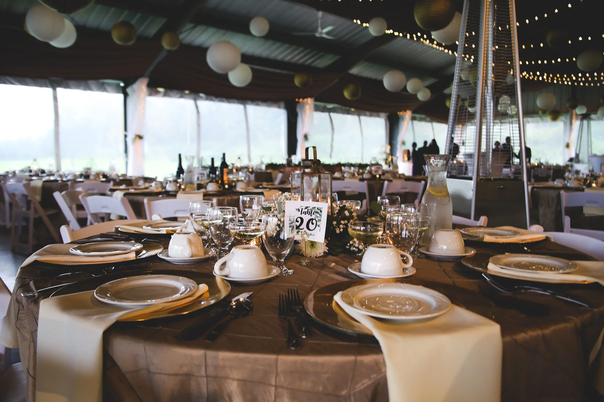 Wedding reception with gold tablescapes and string lights at Genegantslet pavilion